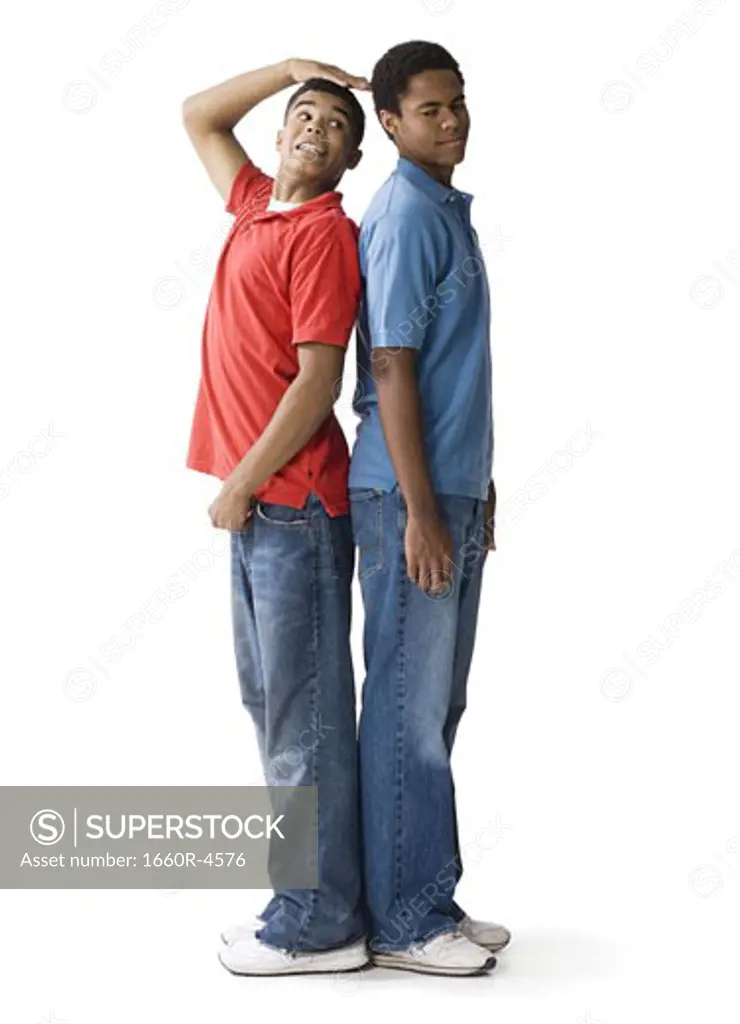 Profile of a teenage boy and a young man standing back to back