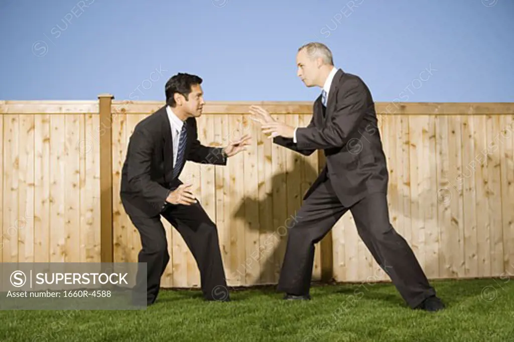 Profile of two businessmen playing and rough housing