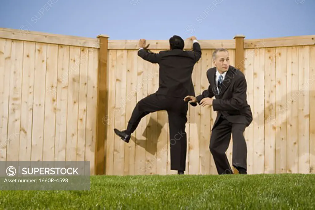 Low angle view of two businessmen playing on a lawn