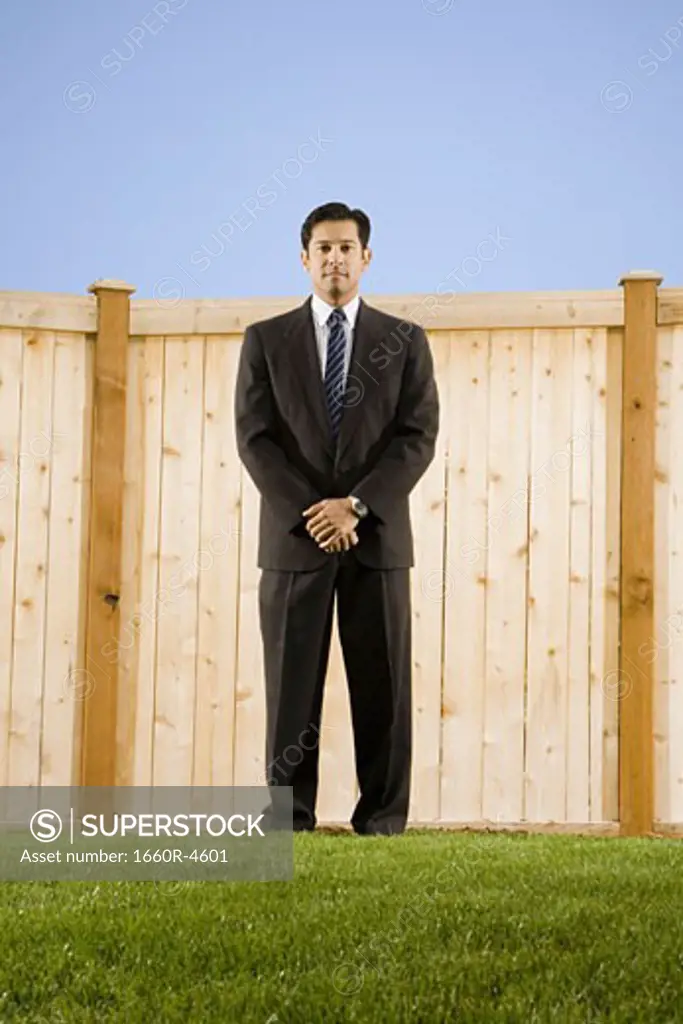 Low angle view of a businessman standing in front of a wall