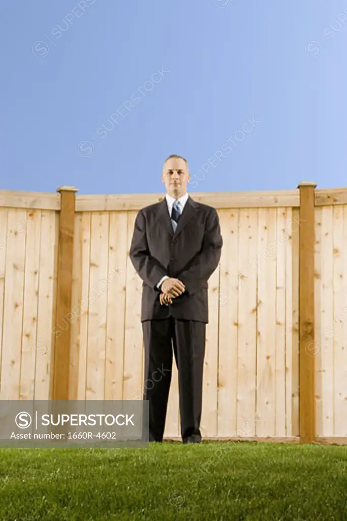 Low angle view of a businessman standing in front of a wall