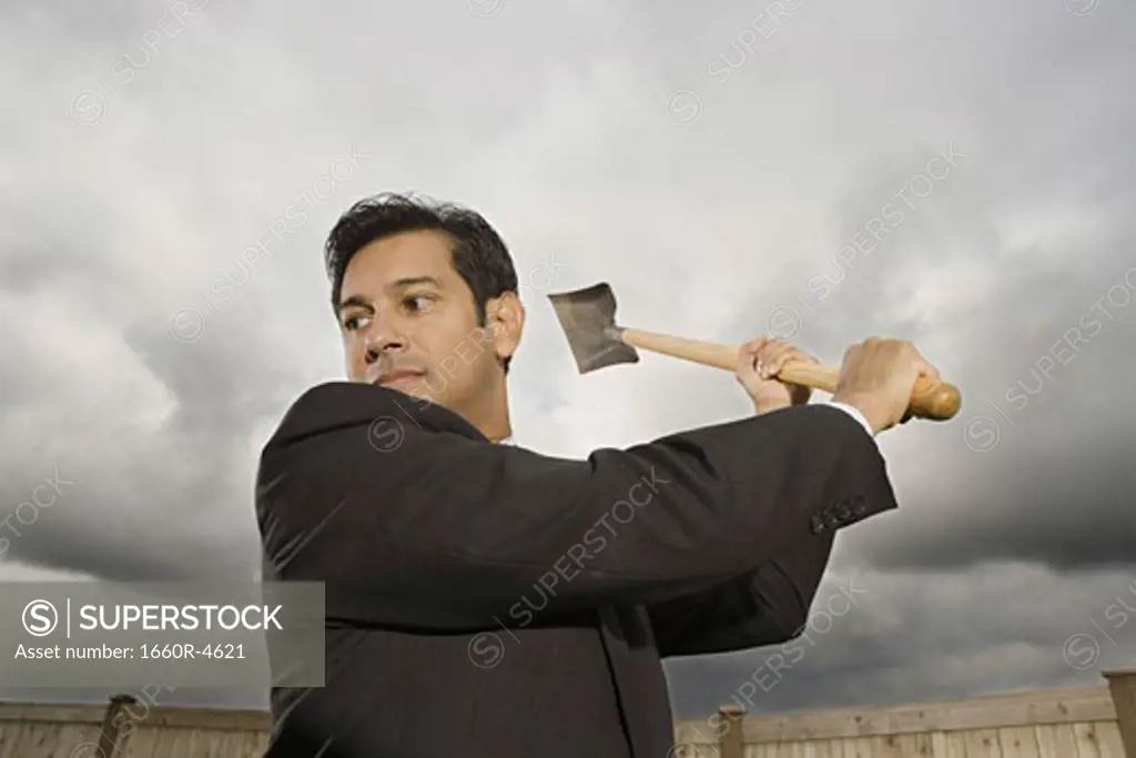 Low angle view of a businessman swinging a shovel