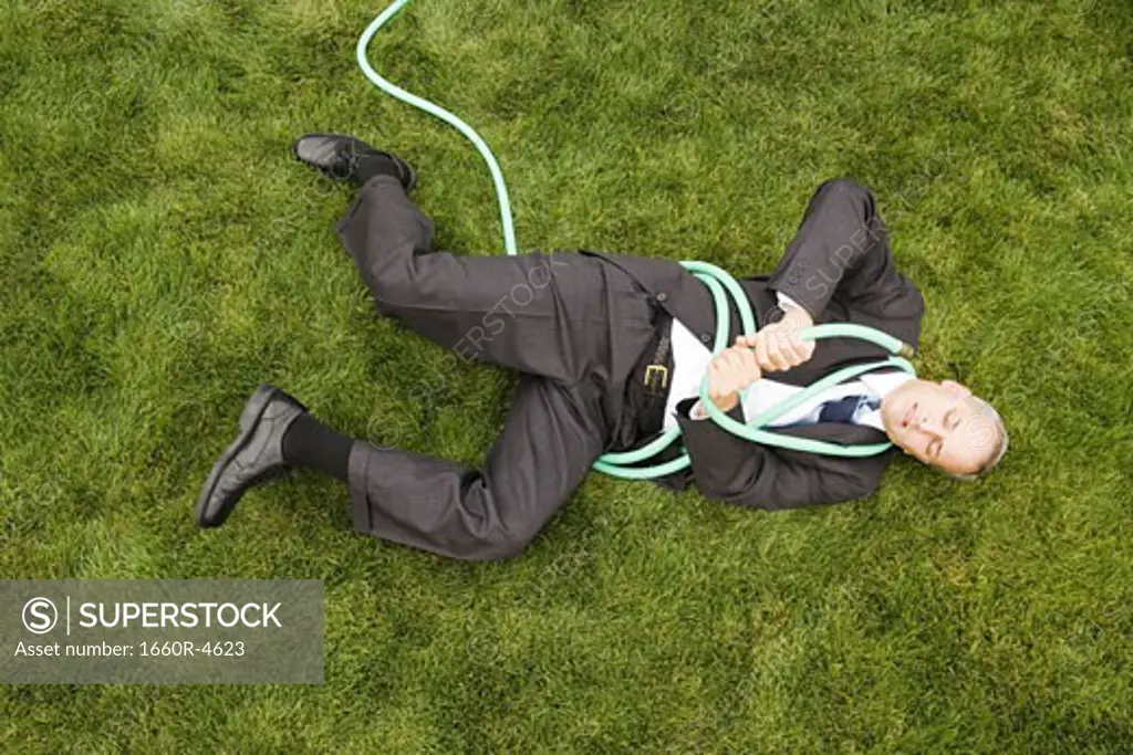 High angle view of a businessman playing with a hose