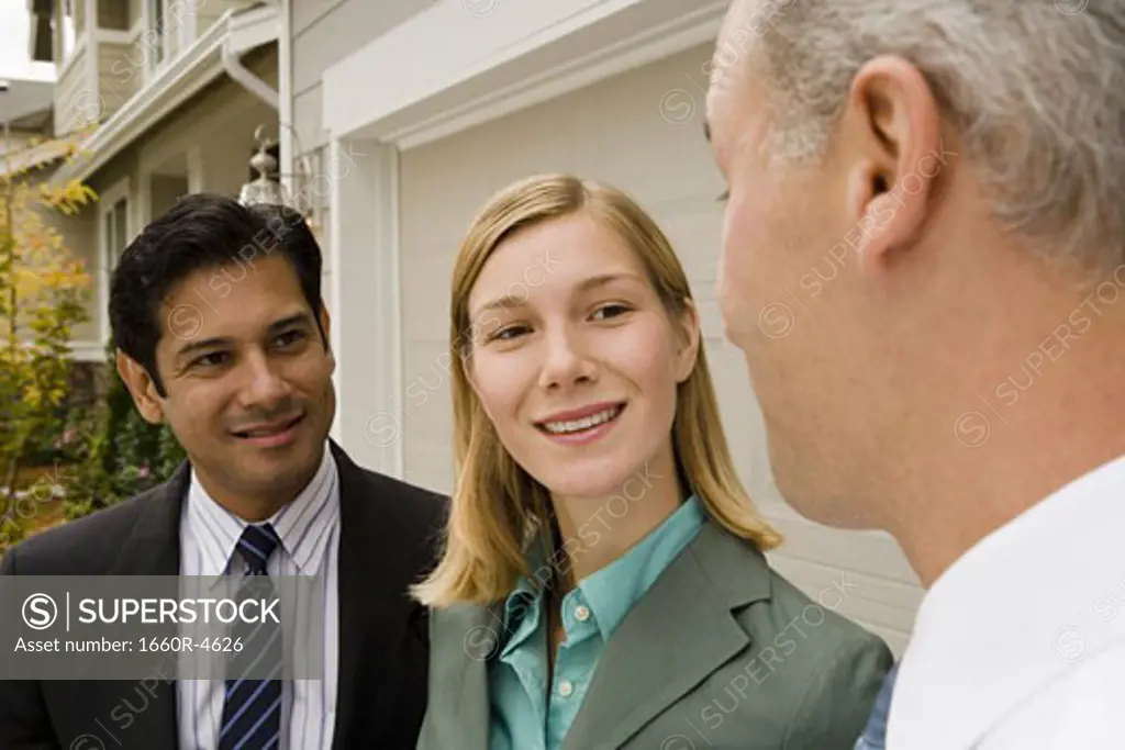 Close-up of a businesswoman and two businessmen smiling