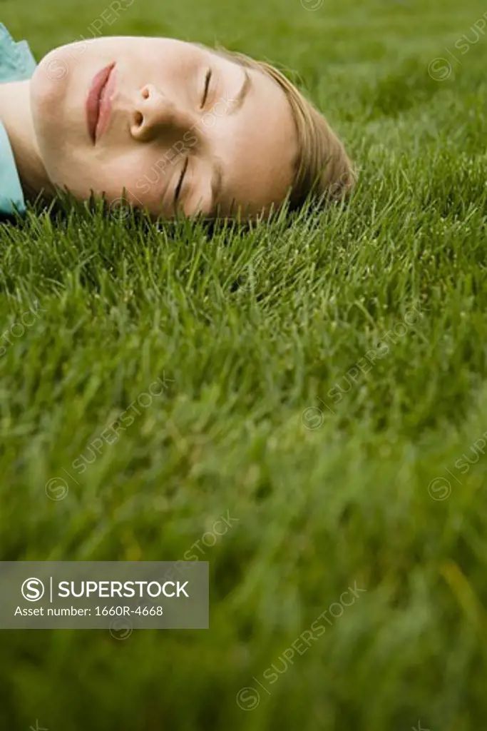 High angle view of a young woman sleeping on grass