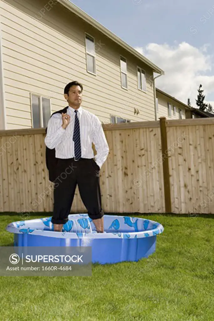 Businessman standing in a wading pool
