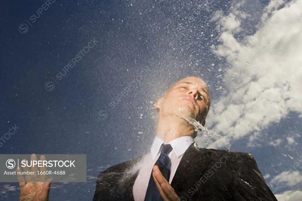 Low angle view of a businessman getting hosed