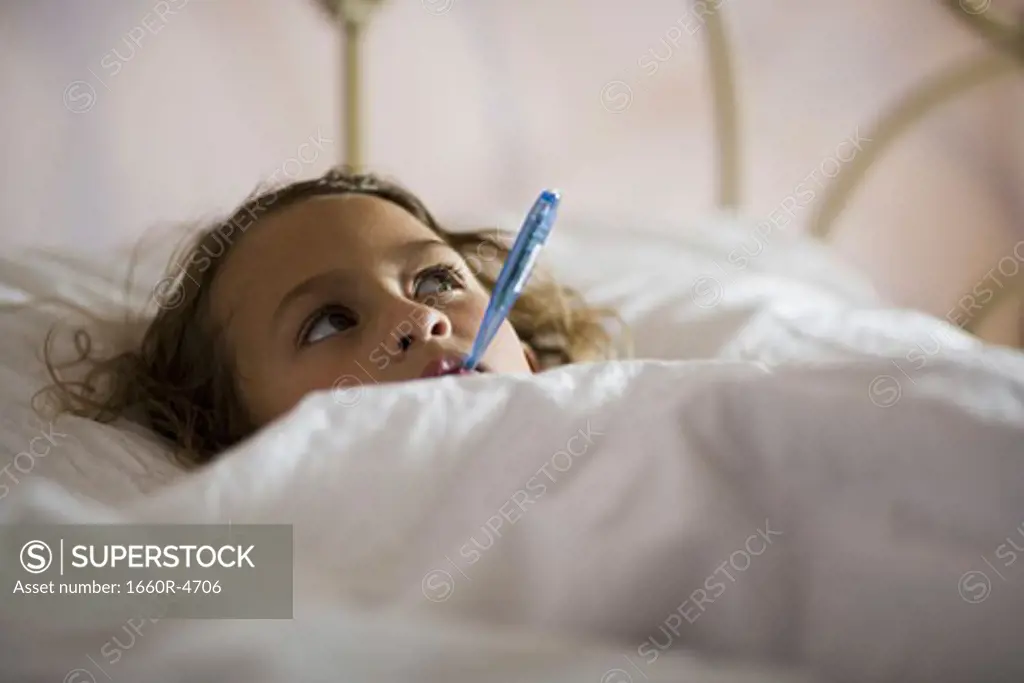 High angle view of a girl with a thermometer in her mouth
