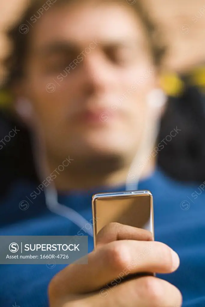Close-up of a young man holding an MP3 Player