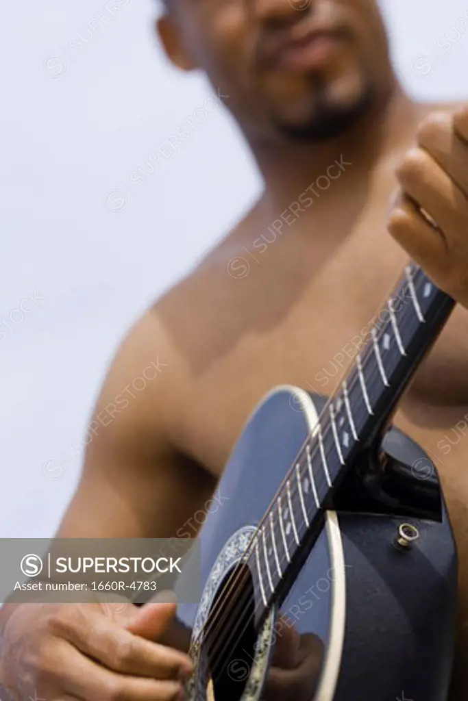 Close-up of a young man playing a guitar