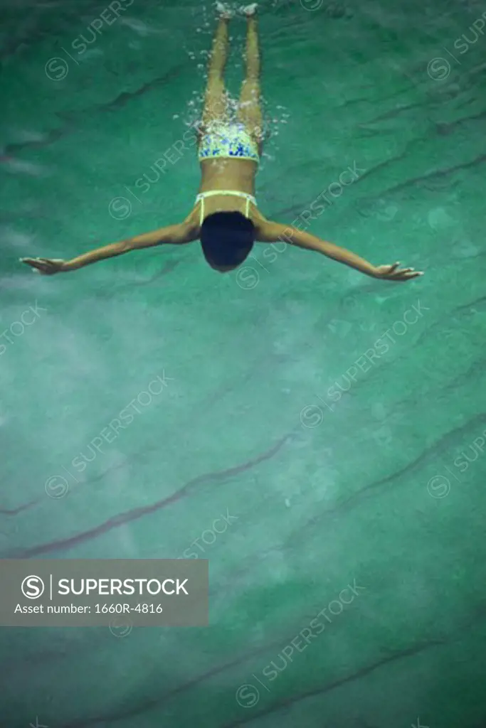 High angle view of a young woman swimming under water