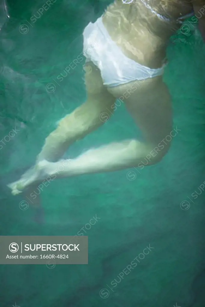 Low section view of a young woman swimming