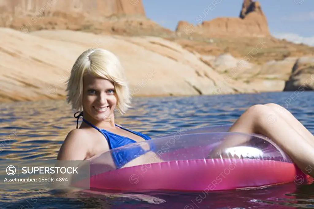 Portrait of a young woman sitting in an inflatable raft in a lake