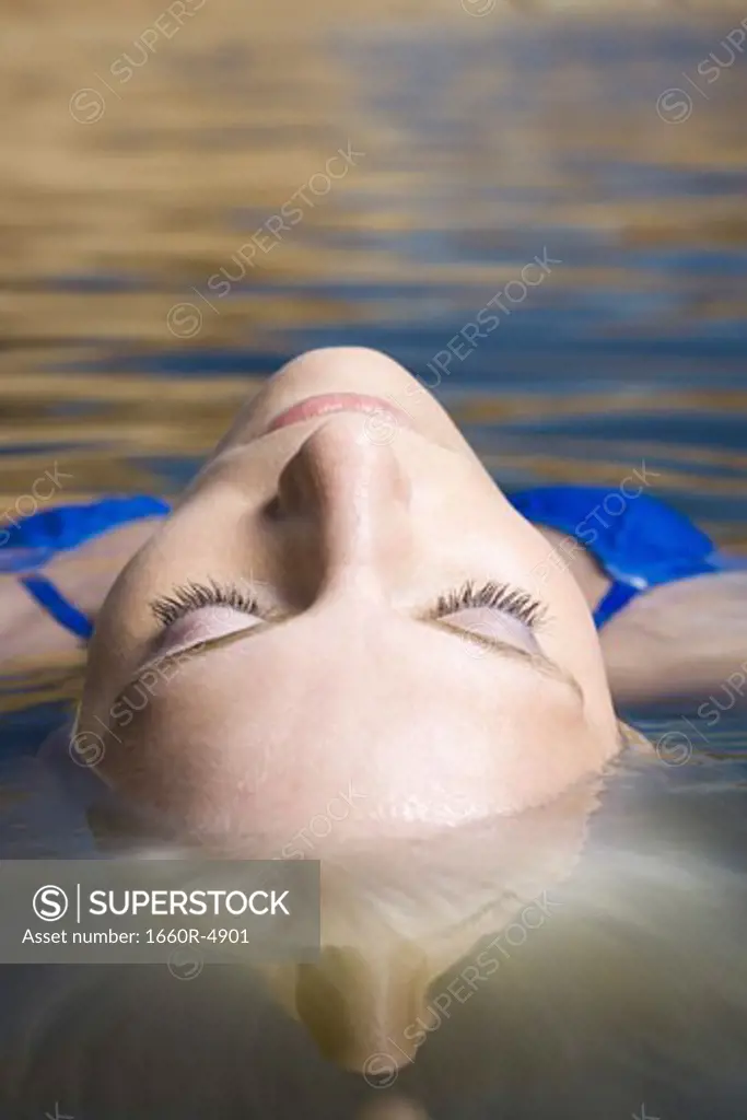 Close-up of a young woman floating on the surface of a lake
