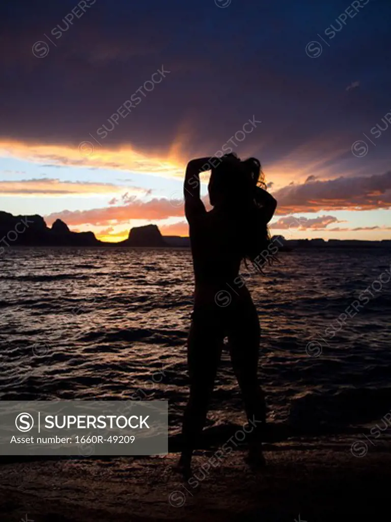 USA, Utah, Lake Powell, Silhouette of woman standing near lake during sunset
