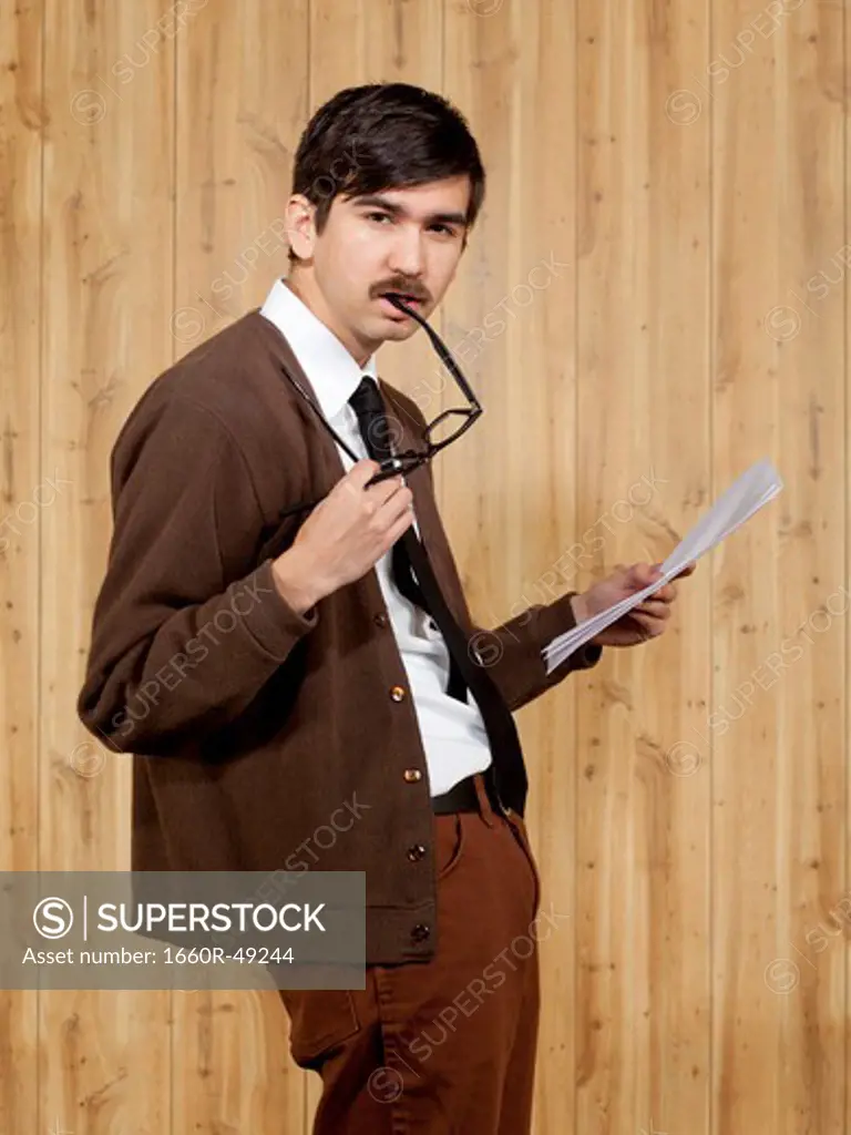 Portrait of businessman reading document in office