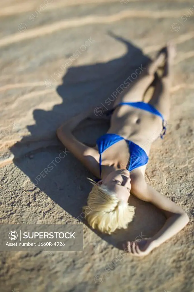 High angle view of a young woman lying on a rock