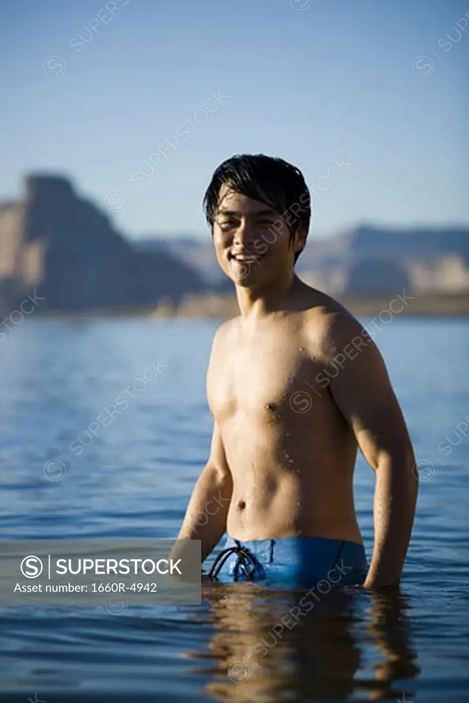 Portrait of a young man standing in a lake