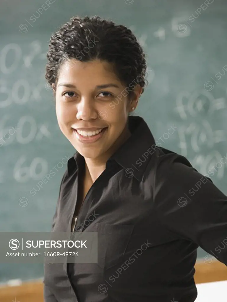 Young person  posing in front of chalkboard