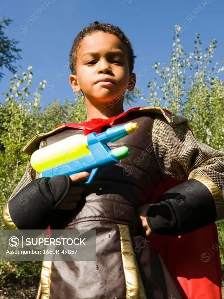 Boy posing in costume and water gun