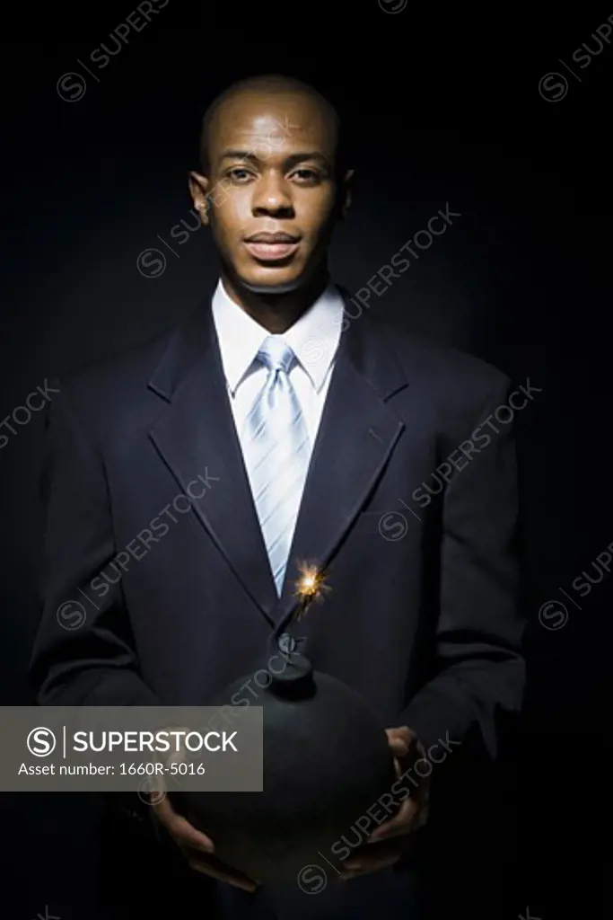 Portrait of a businessman holding a bomb