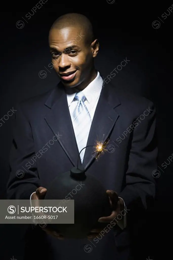 Portrait of a businessman holding a bomb