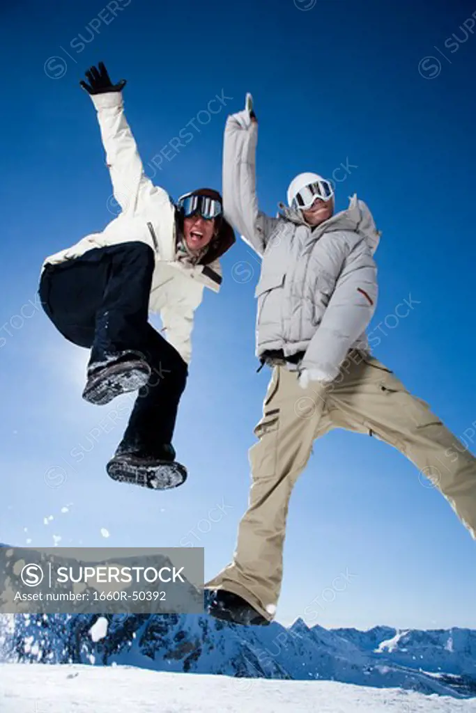 Two friends jumping outside in the snow