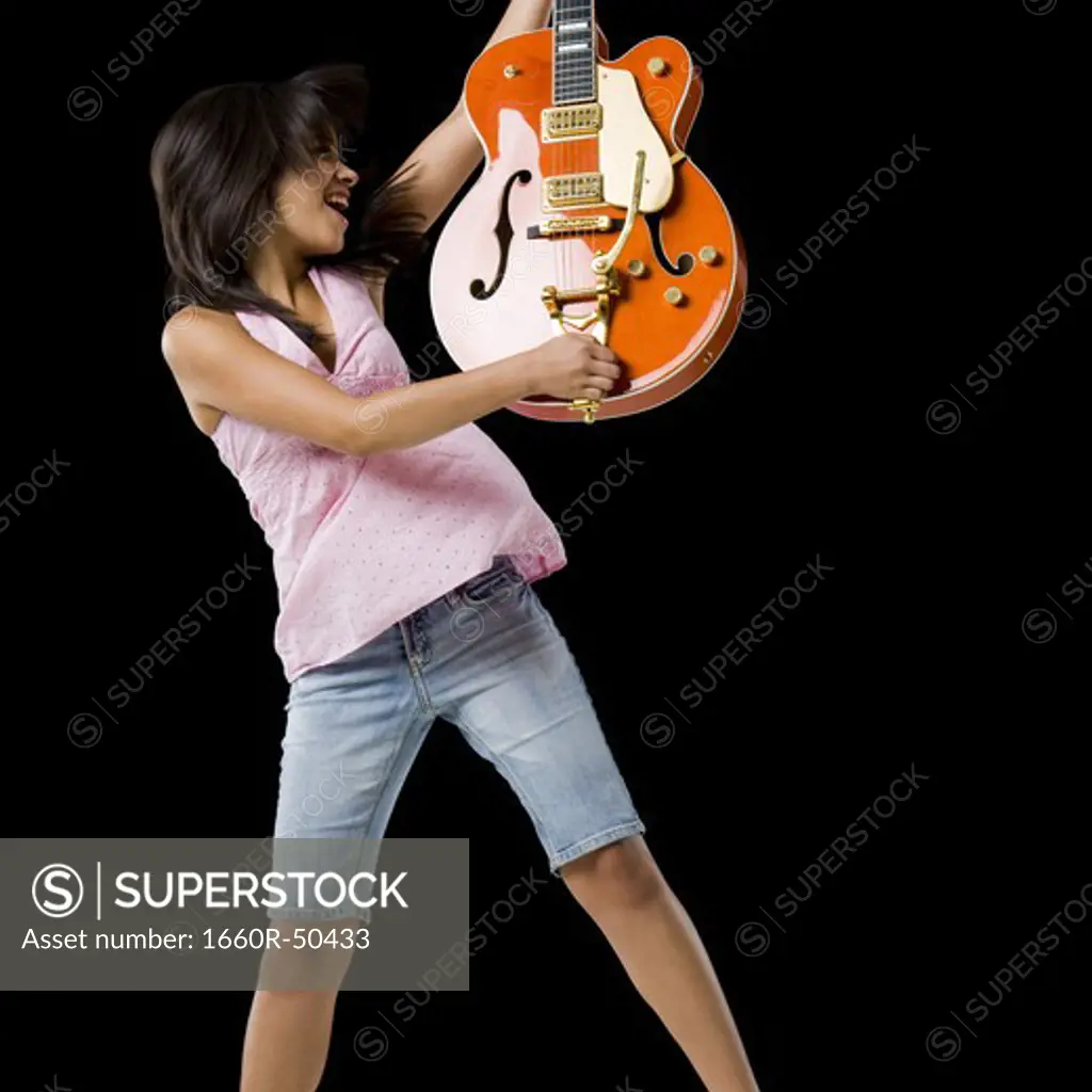 Woman with guitar smiling and dancing