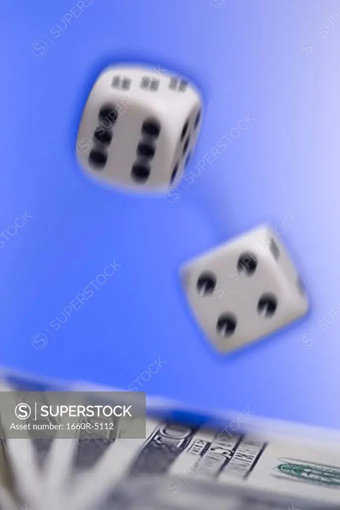 Close-up of a pair of dice above US currency