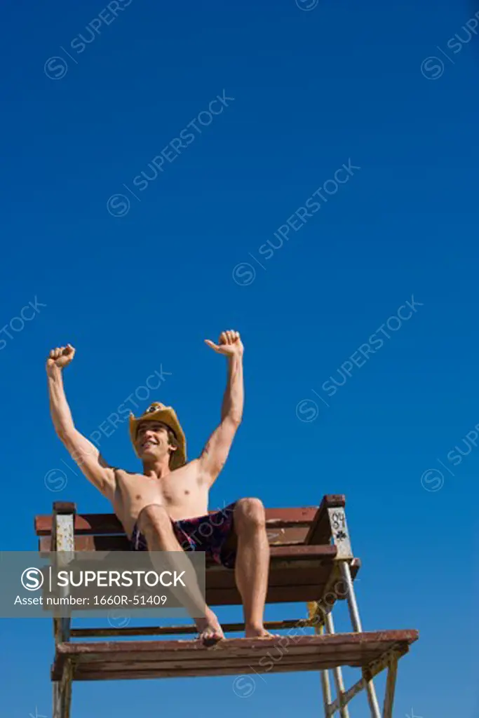 Man with cowboy hat in lifeguard chair