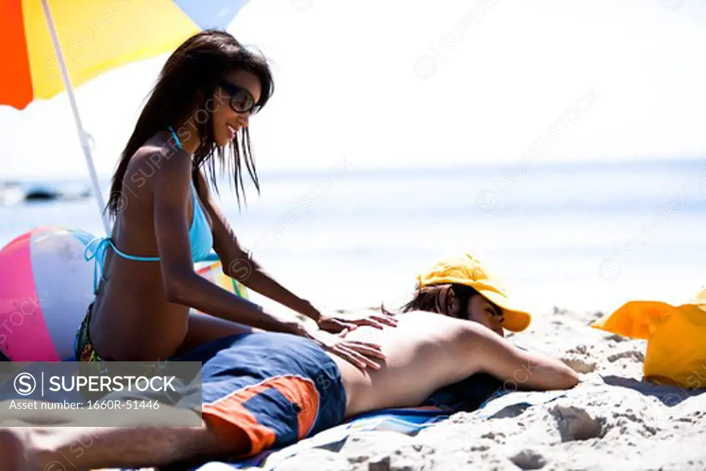 Woman applying sun screen to man