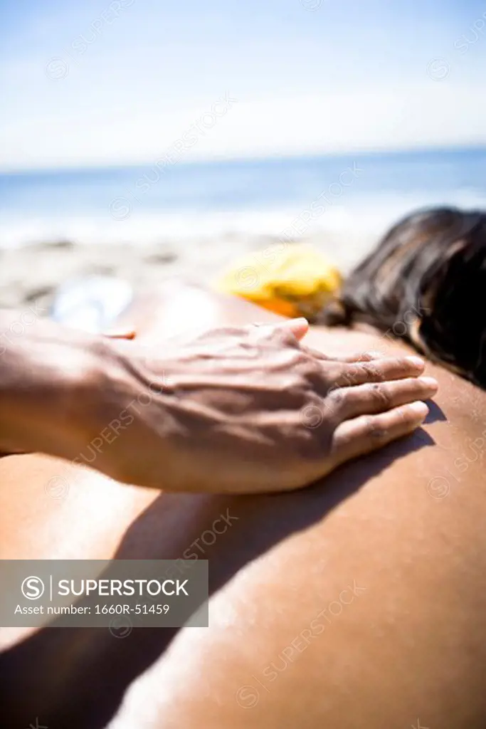 Woman applying sun screen to man