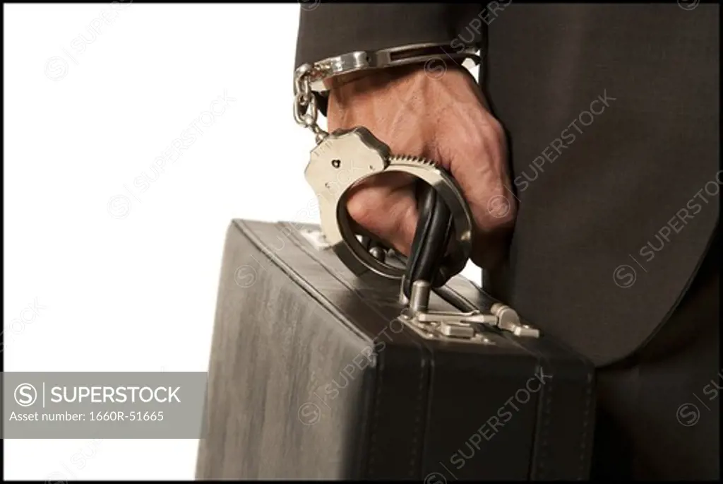 Businessman handcuffed to a briefcase