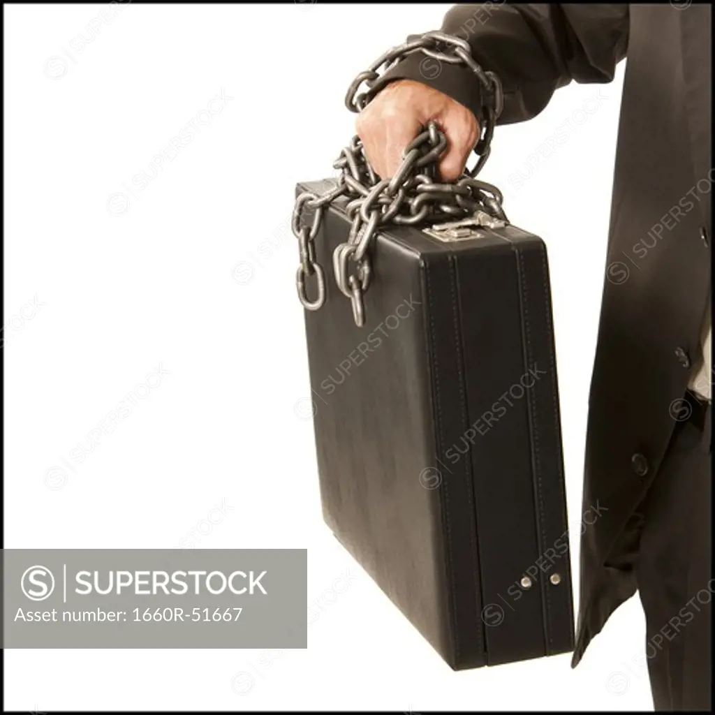 Businessman chained to briefcase