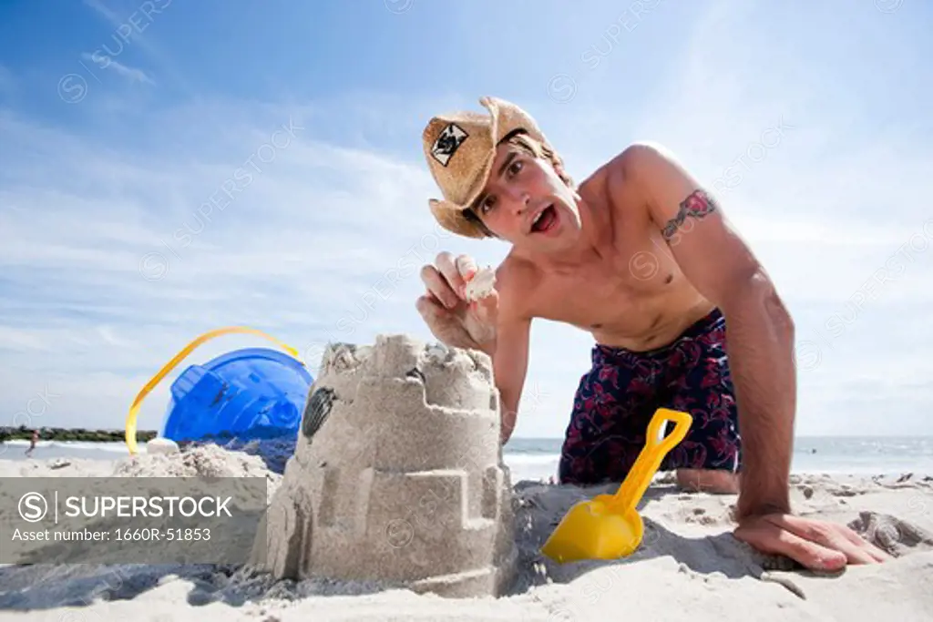 Man building a sand castle at the beach