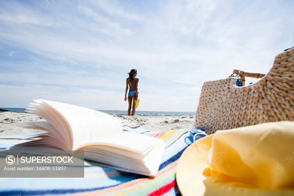 Book and beach bag on sand at beach