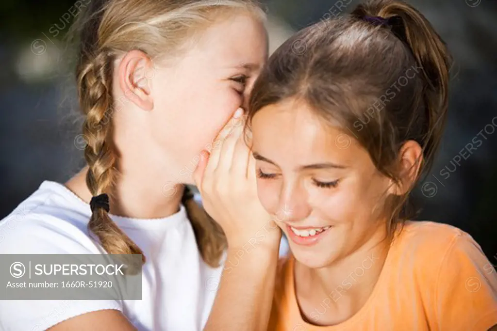 Two girls outside whispering