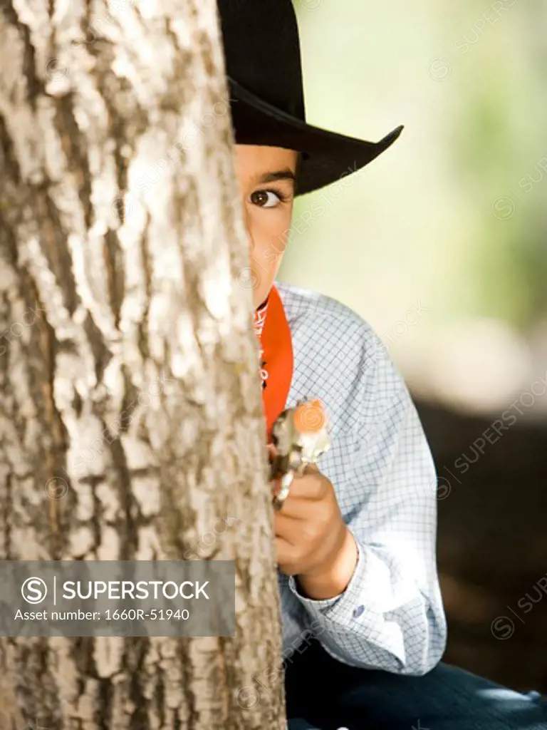 Boy in cowboy costume with toy gun