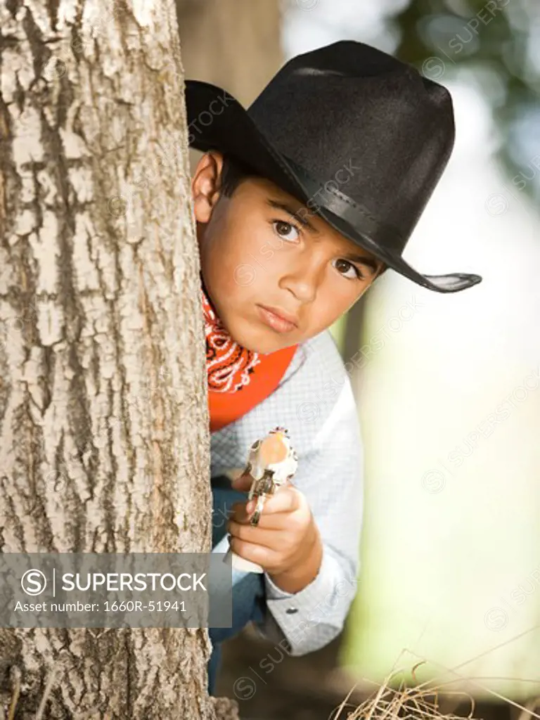 Boy in cowboy costume with toy gun