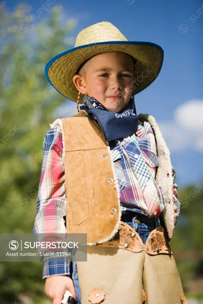 Boy in cowboy costume outside