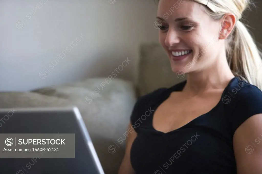 Woman on a laptop looking at a business card