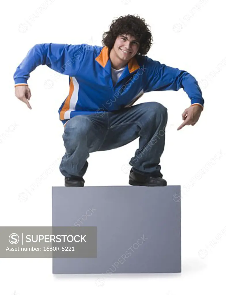 Portrait of a teenage boy sitting on a blank sign