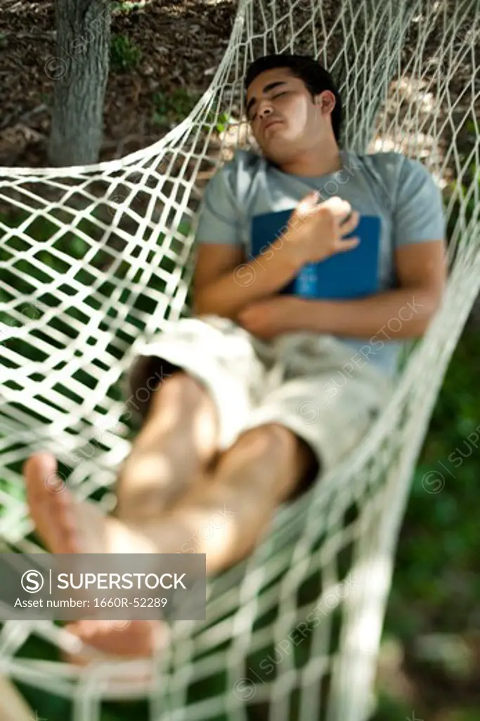 Man who fell asleep reading in a hammock