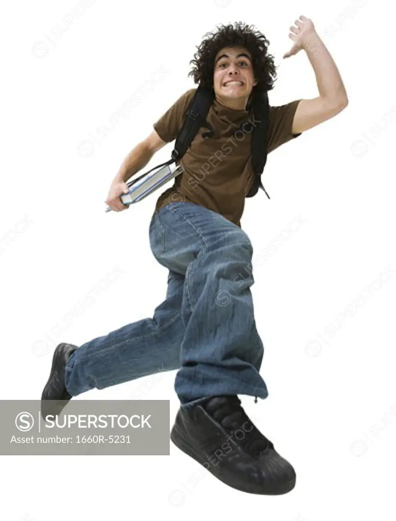 Portrait of a teenage boy making a face and jumping in mid-air