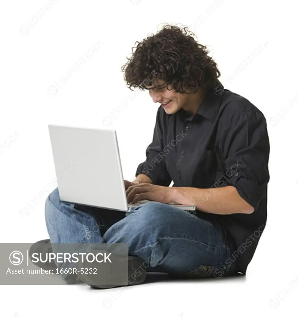 Teenage boy sitting and using a laptop