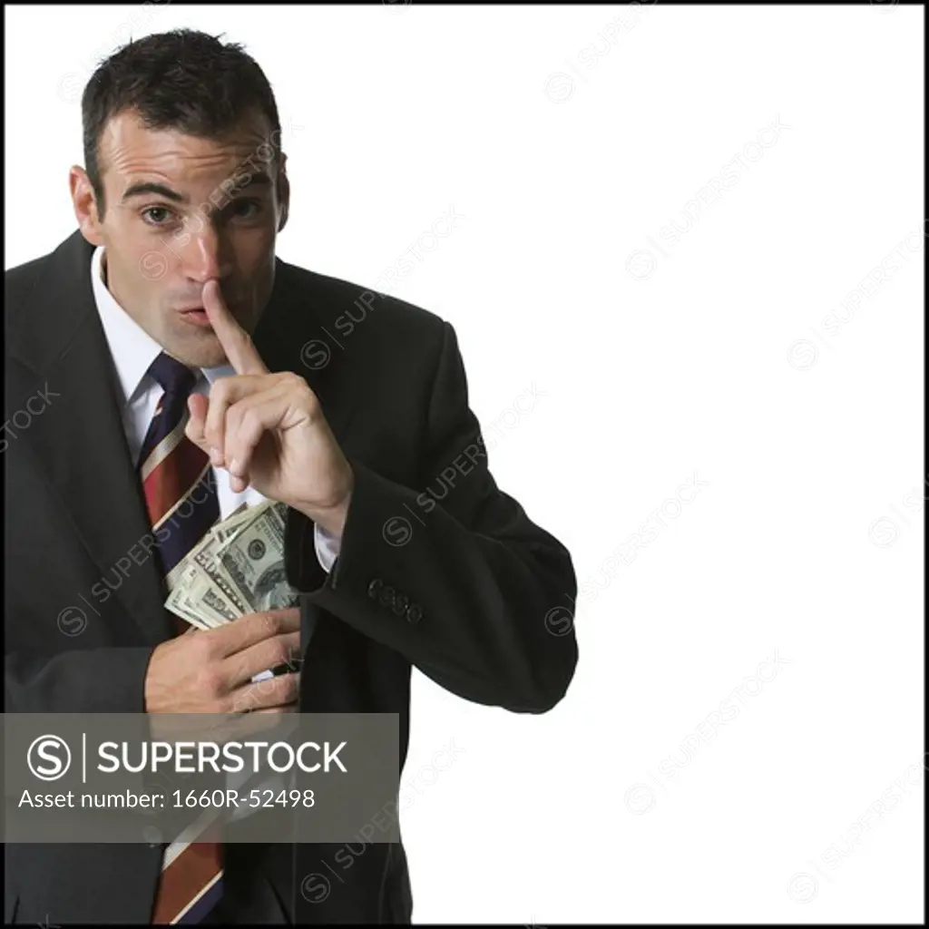 Businessman putting money into his jacket