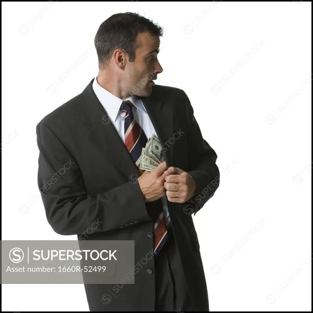 Businessman putting money into his jacket