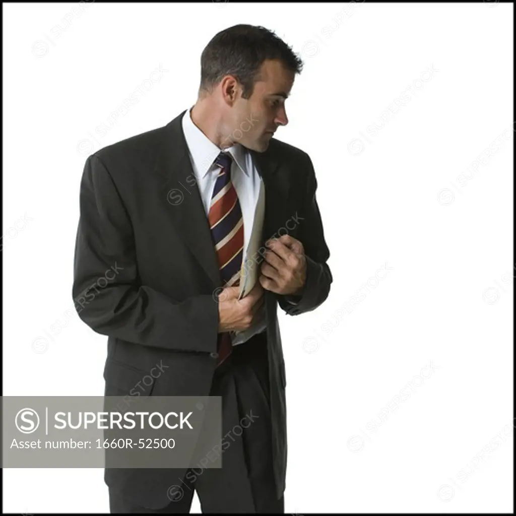 Businessman putting files into his jacket