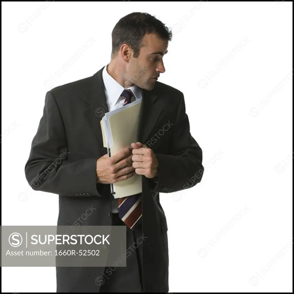 Businessman putting files into his jacket