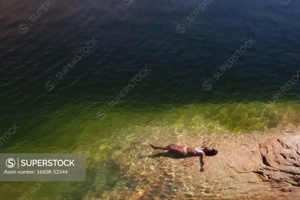Woman lying in the water on back